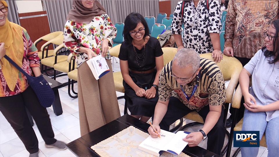 Managing Partner DDTC Darussalam memberikan tanda tangan di buku Konsep dan Studi Komparasi Pajak Pertambahan Nilai yang telah dibagikan secara gratis kepada peserta. 