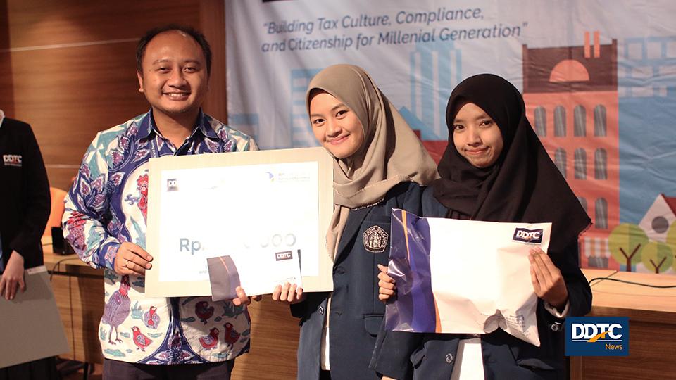 Partner Research and Traning Service DDTC B. Bawono Kristiaji memberikan hadiah kepada juara IV DDTCNews Tax Competition 2018. Juara IV mendapatkan uang tunai senilai Rp2 juta, buku, dan souvenir.