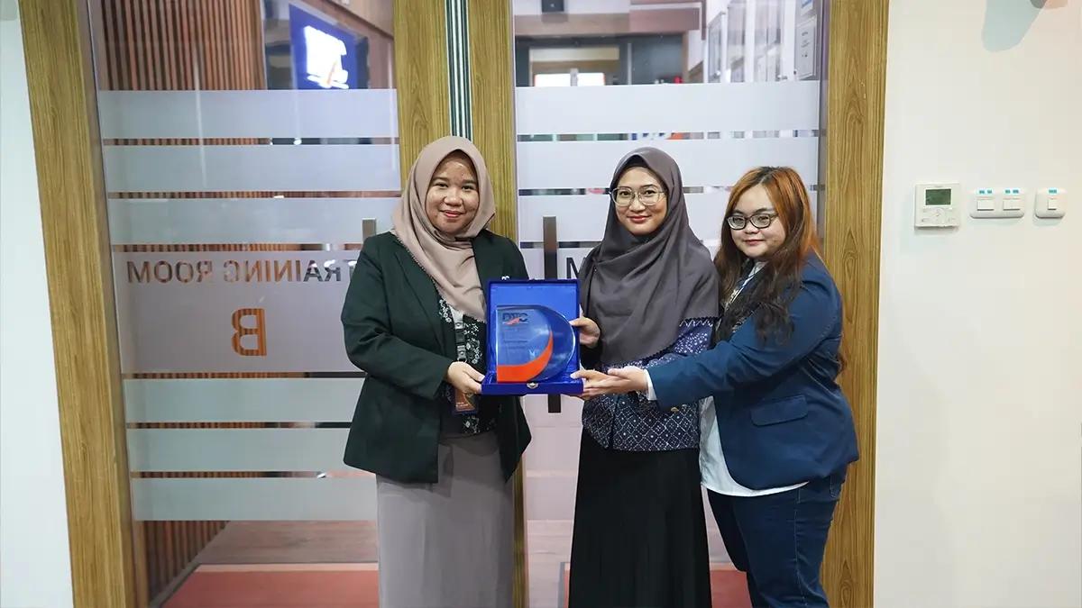 Dosen D3 Akuntansi Perpajakan Universitas Trisakti Mauliddini Nadhifah menerima plakat dari Human Capital Lead DDTC Adinda Nur Larasati dalam company visit di Menara DDTC, Kamis (13/6/2024).